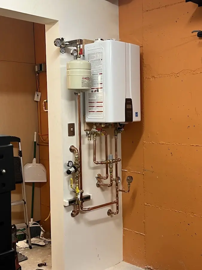 Plumbing technician inspecting water heater connections in North Platte